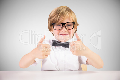 Composite image of cute pupil showing thumbs up