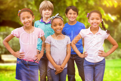 Composite image of cute pupils smiling at camera in classroom