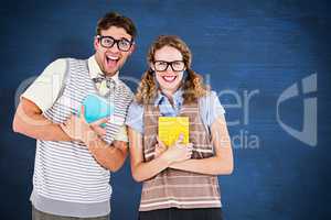 Composite image of geeky hipster couple holding books and smilin