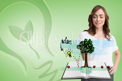 Composite image of pretty woman showing a book