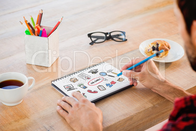 Composite image of creative businessman writing notes on noteboo