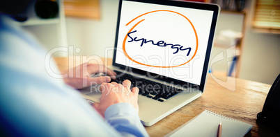Synergy against businessman working on his laptop