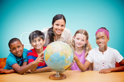 Composite image of cute pupils and teacher looking at globe in l