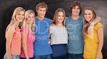 Composite image of a group of friends smiling and holding each o