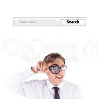 Composite image of geeky businessman looking through magnifying