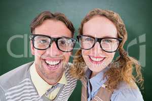 Composite image of happy geeky hipster smiling at camera