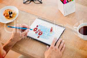 Composite image of man writing notes on notebook