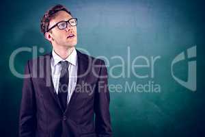 Composite image of young businessman thinking and looking up