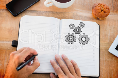 Composite image of man writing notes on diary