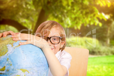 Composite image of cute pupil holding globe