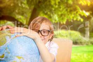 Composite image of cute pupil holding globe