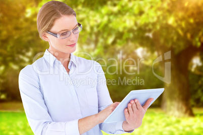 Composite image of businesswoman using tablet pc