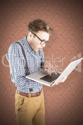 Composite image of geeky businessman using his laptop