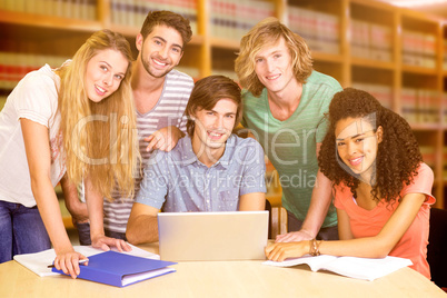 Composite image of college students using laptop in library