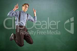 Composite image of geeky hipster jumping and pointing