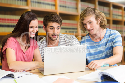 Composite image of college students using laptop in library