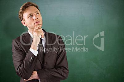 Composite image of young businessman thinking with hand on chin