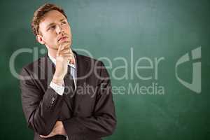 Composite image of young businessman thinking with hand on chin