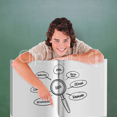 Composite image of young man showing a book