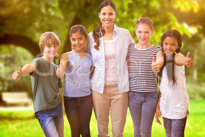 Composite image of cute pupils and teacher smiling at camera in