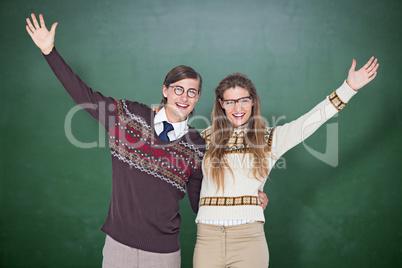 Composite image of happy geeky hipster couple embracing