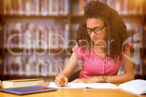 Composite image of student sitting in library writing