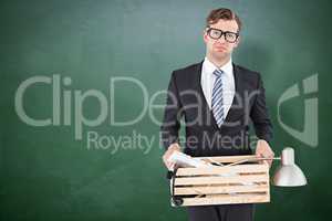 Composite image of sad geeky businessman holding box of his thin