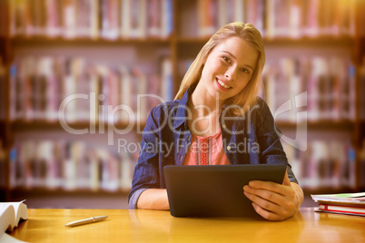 Composite image of student studying in the library with tablet