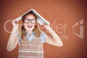 Composite image of geeky hipster woman covering her head with he