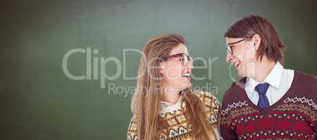 Composite image of happy geeky hipster couple looking at each ot