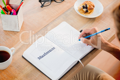 Maximum against man writing notes on diary