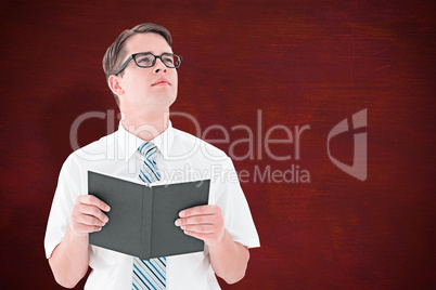 Composite image of geeky businessman reading from book