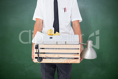 Composite image of fired businessman holding box of belongings