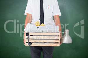 Composite image of fired businessman holding box of belongings