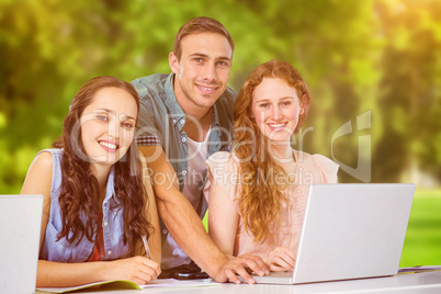 Composite image of fashion students using laptop