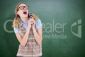 Composite image of geeky hipster woman singing into a microphone