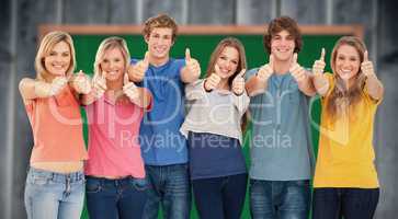 Composite image of six friends giving thumbs up as they smile