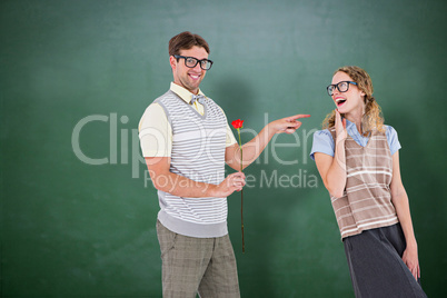 Composite image of geeky hipster holding rose and pointing his g