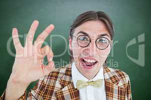 Composite image of geeky hipster doing the ok sign