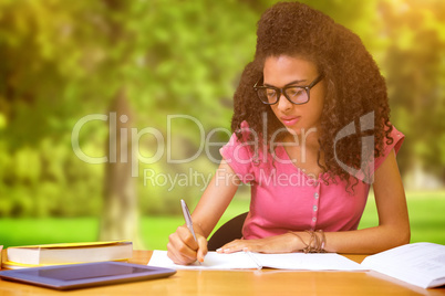 Composite image of student sitting in library writing