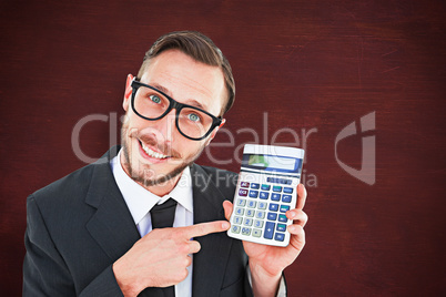 Composite image of geeky businessman pointing to calculator