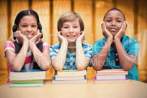 Composite image of cute pupils looking at camera in library