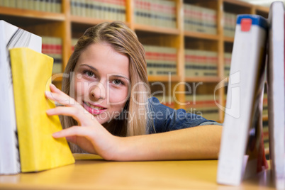 Composite image of pretty student in the library