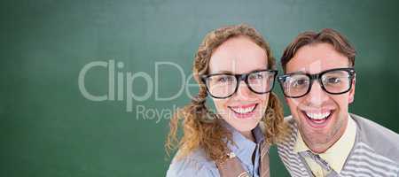 Composite image of happy geeky hipster smiling at camera