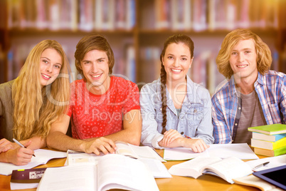 Composite image of college students doing homework in library