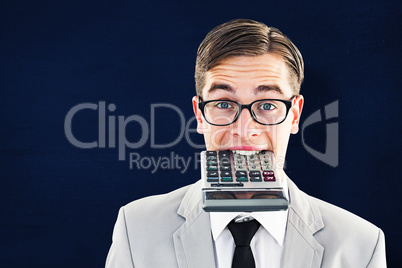 Composite image of geeky smiling businessman biting calculator