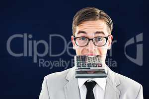 Composite image of geeky smiling businessman biting calculator