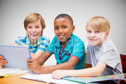 Composite image of cute pupils using tablet computer in library