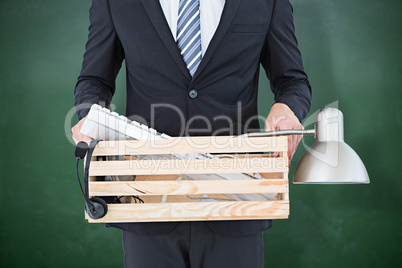 Composite image of businessman holding box of his things