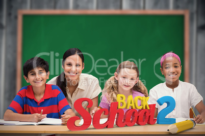 Composite image of pretty teacher helping pupils in library